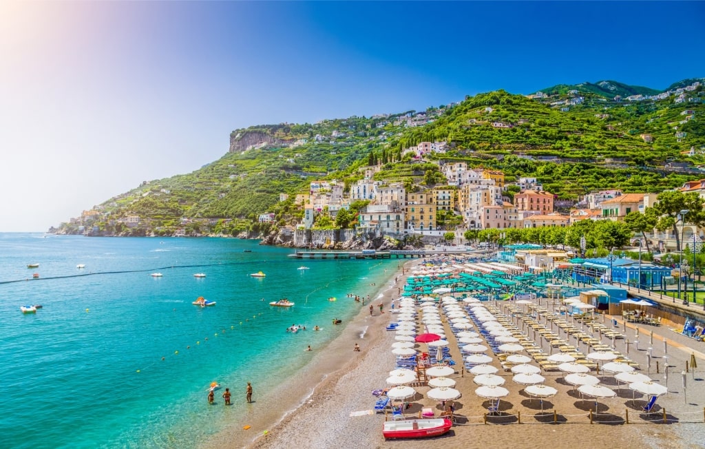 Coastal view of Minori town in Italy with sandy beach, pastel houses, and hills