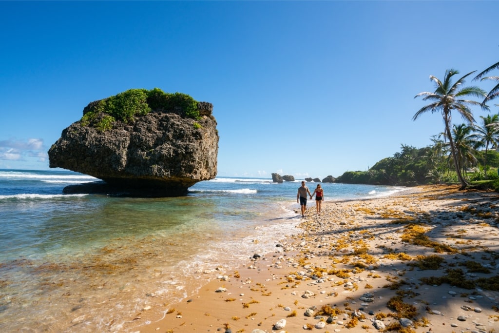 Couple enjoying the natural beauty of Bathsheba Beach, Barbados, one of relaxing vacation spots