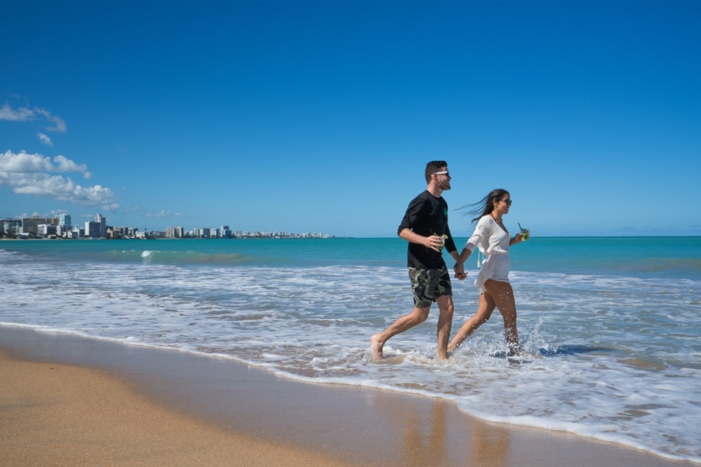 Couple enjoying on the sandy shores of Isla Verde Beach in Puerto Rico