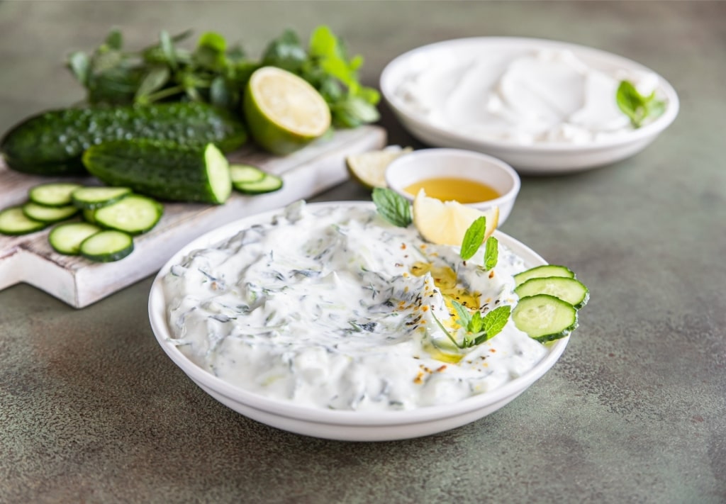 Slices of cucumbers with tzatziki on a plate