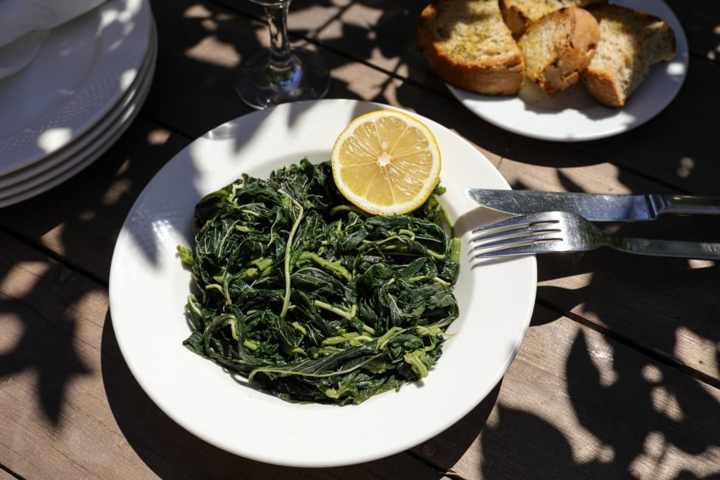 Plate of wild greens with lemon on the side