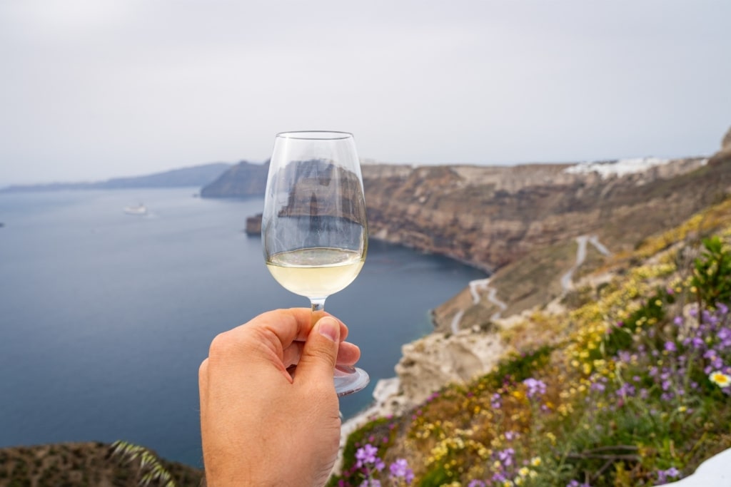 Glass of assyrtiko with view of Santorini