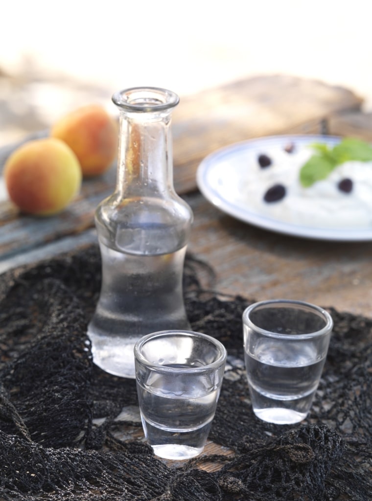 Bottle of ouzo with shot glasses