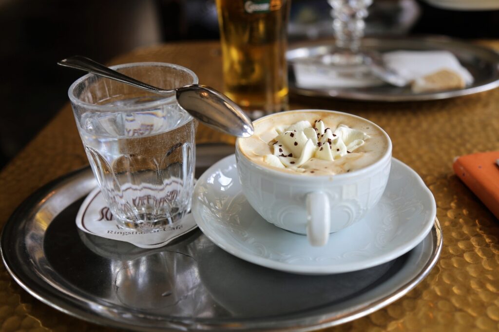 Classic Viennese coffee with glass of water in historic café