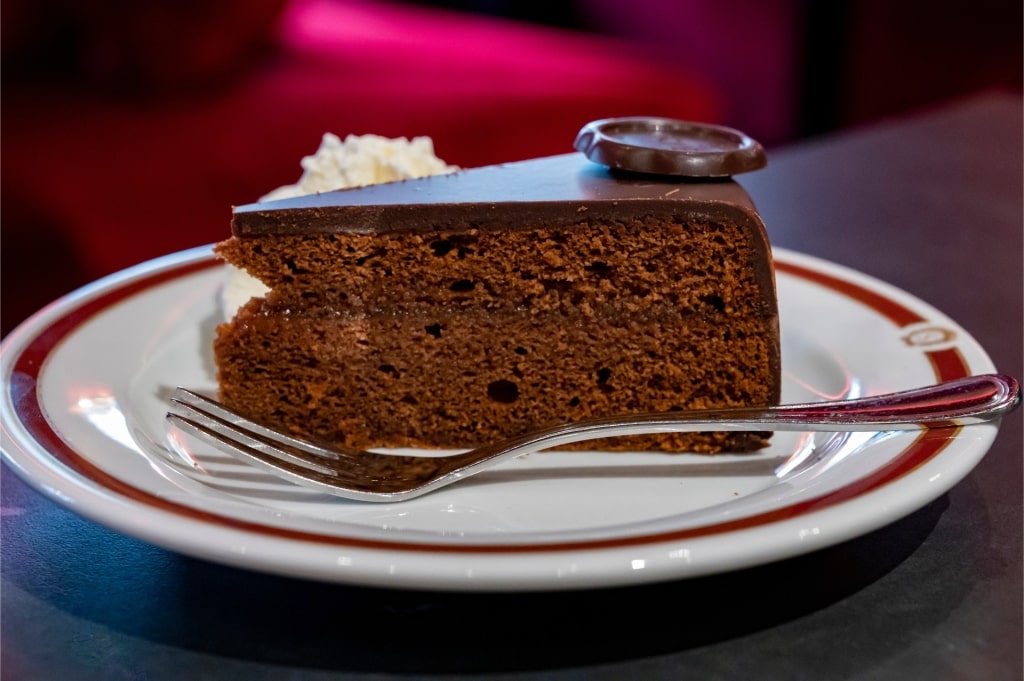 Classic Viennese Sacher-Torte slice served with a dollop of whipped cream