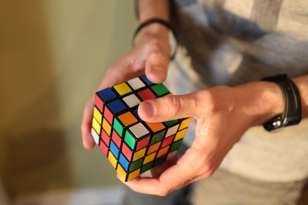 Person solving a Rubik’s Cube with both hands