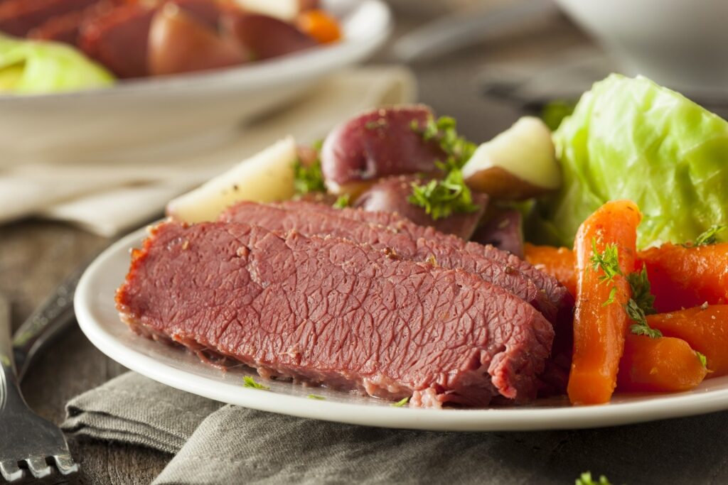 Slices of corned beef with vegetables on the side