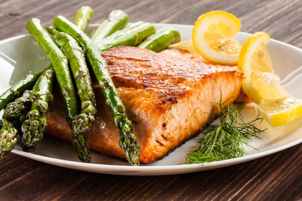 Plate of grilled salmon with lemon and asparagus on the side