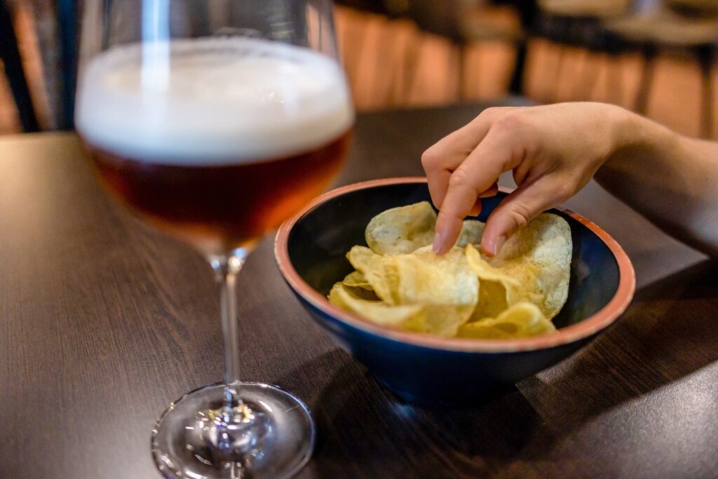 Person eating Irish potato crisps at a pub