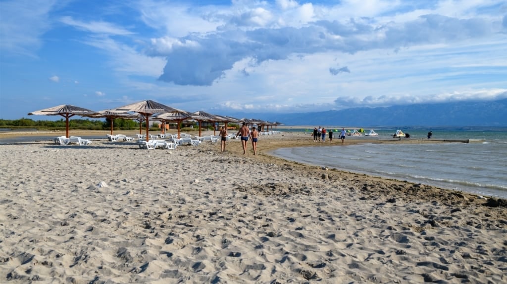 Tourists walking on the sandy Queen’s Beach in Nin
