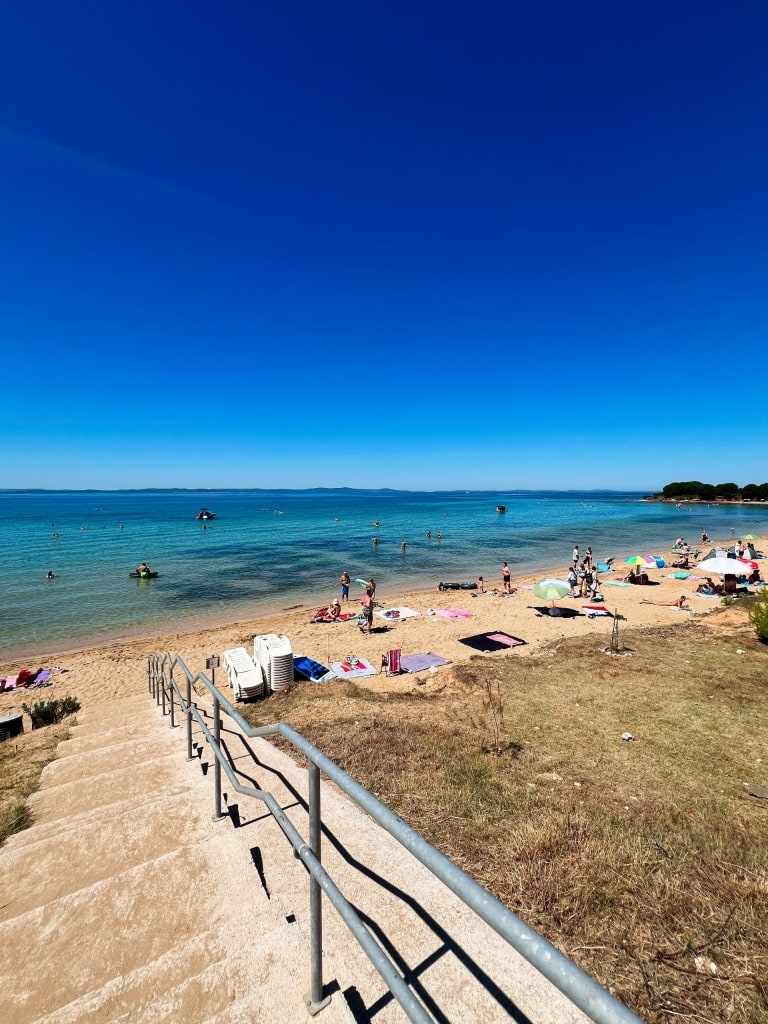 Tourists relaxing at Plaza Bilotinjak, a popular beach near Nin