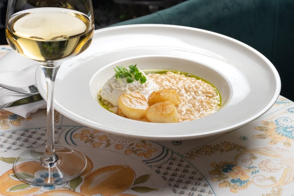 Creamy risotto served on a white plate with wine