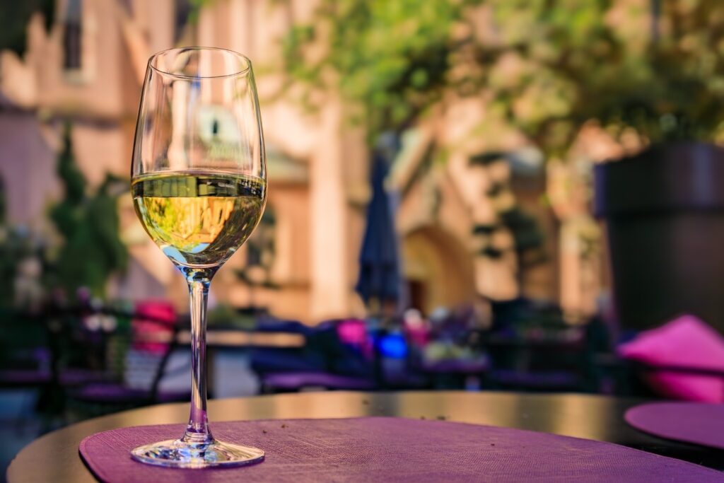 Glass of Alsatian Gewürztraminer white wine at an outdoor restaurant table in Strasbourg