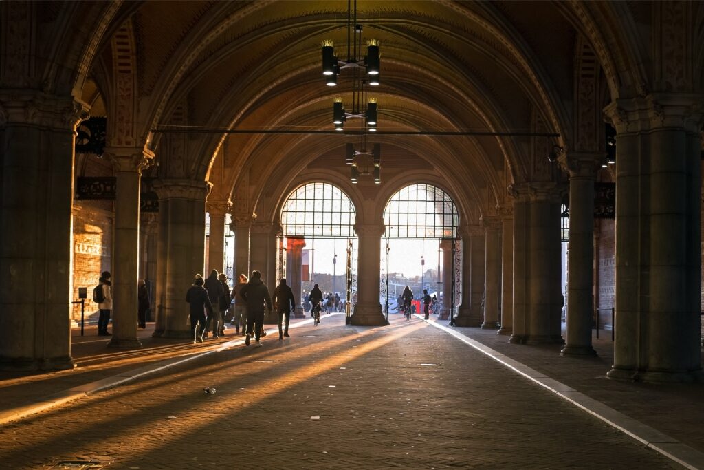 ourists walking through the iconic pedestrian tunnel of the Rijksmuseum in Amsterdam