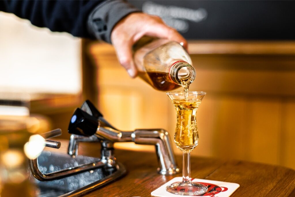 Clear jenever gin filling a small glass at an Amsterdam bar