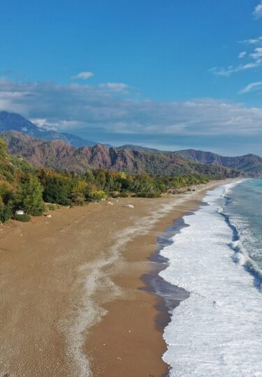 Scenic view of Çıralı Beach with turquoise waters and mountains in Antalya