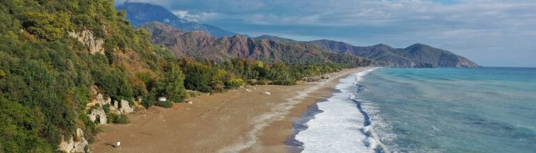 Scenic view of Çıralı Beach with turquoise waters and mountains in Antalya