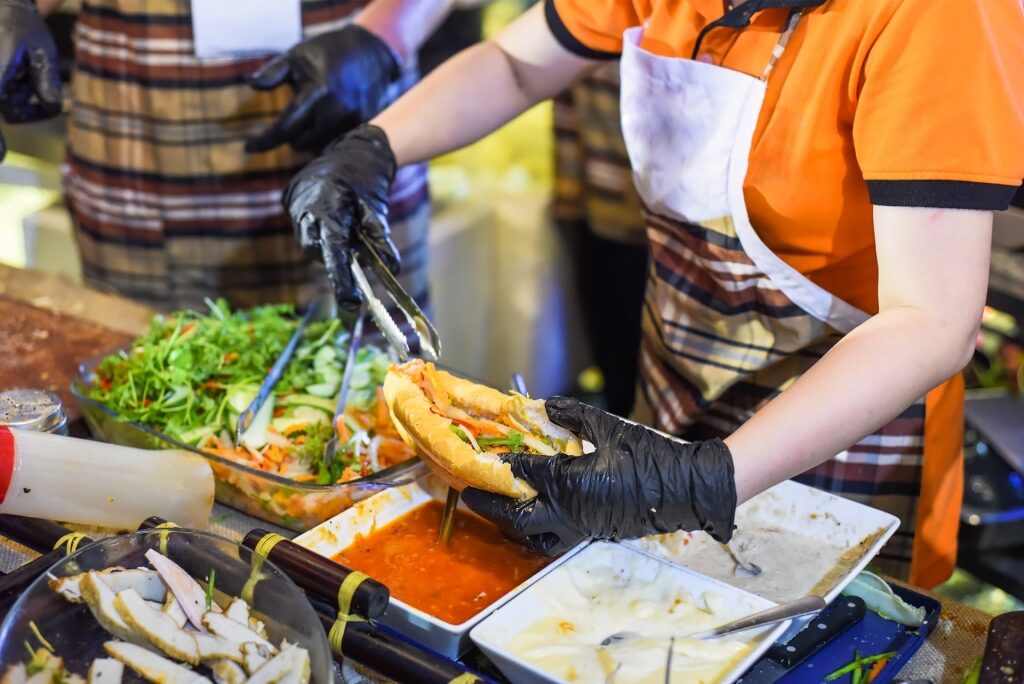 Vendor preparing fresh Vietnamese bánh mì sandwich