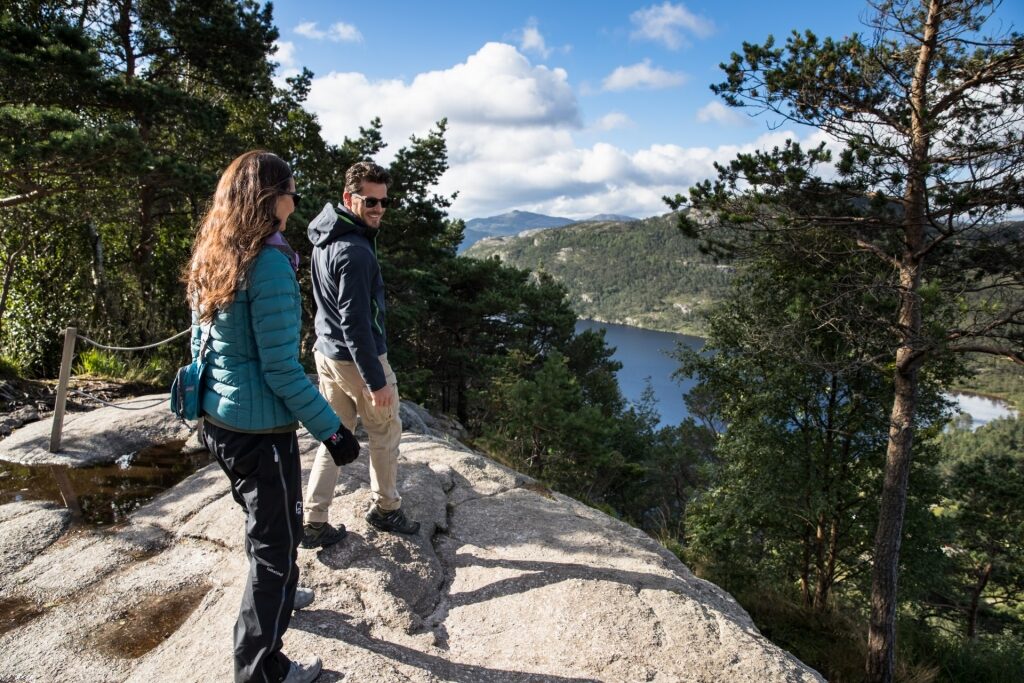 Couple enjoying panoramic views from the cliff of Pulpit Rock in Norway