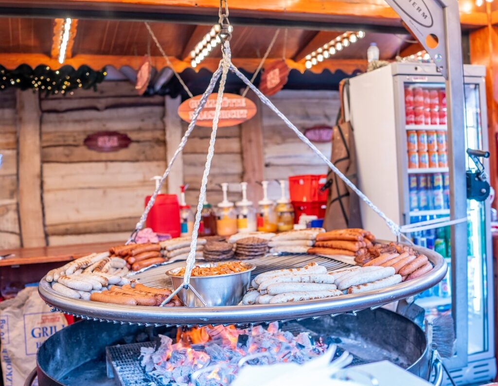 Grilled sausages, and burgers cooking over coals at Maastricht Christmas market