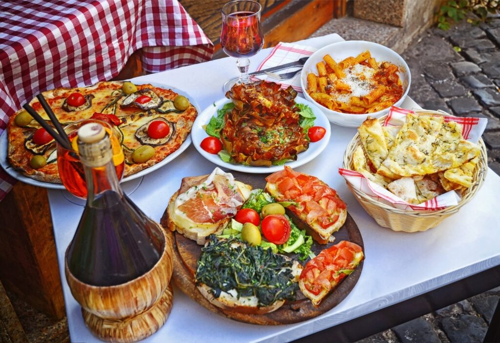 Table set with Italian pasta, pizza, and traditional homemade food in Rome