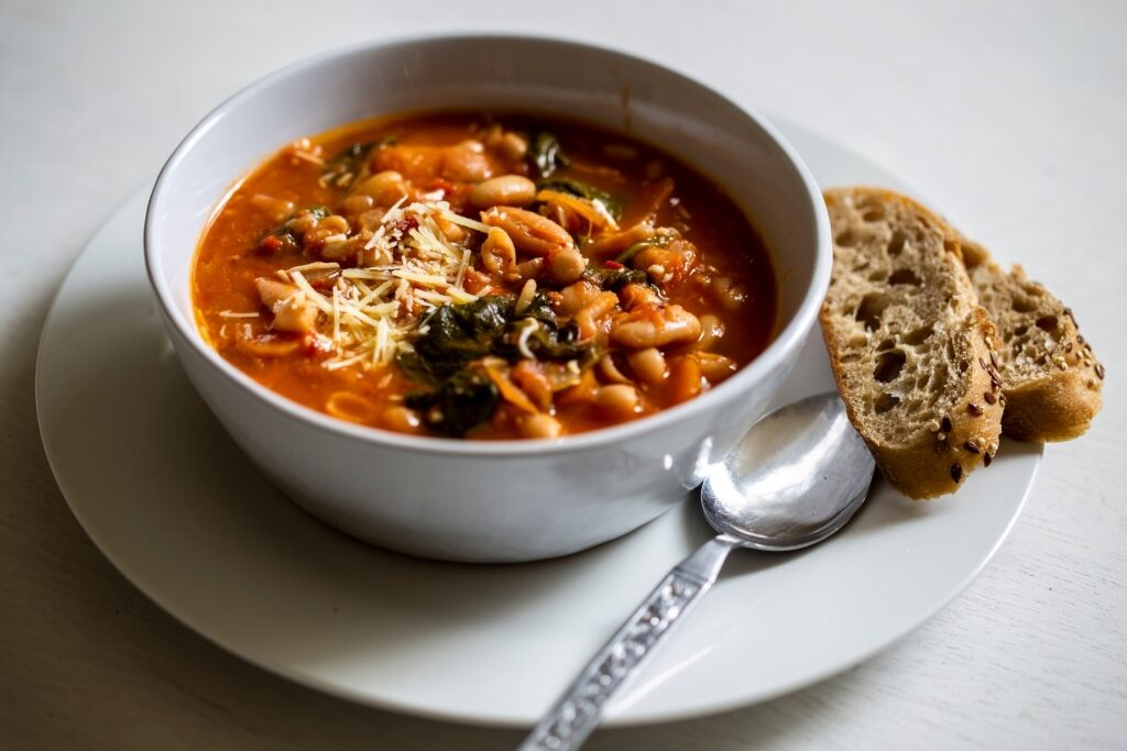Traditional Italian ribollita soup with vegetables, beans, and bread