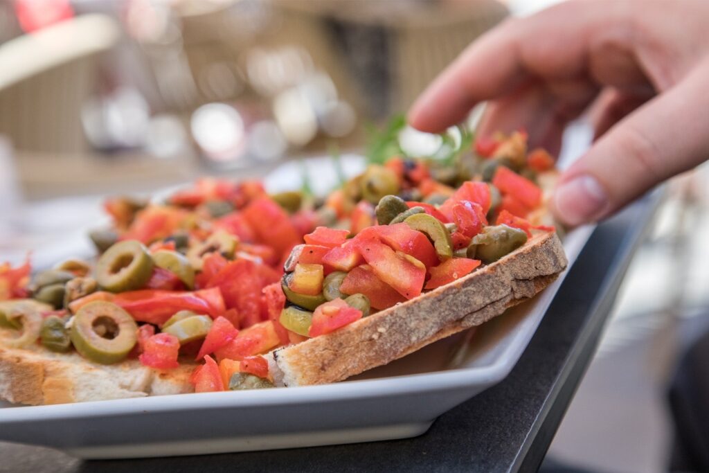 Close-up of Maltese bread with fresh Mediterranean toppings