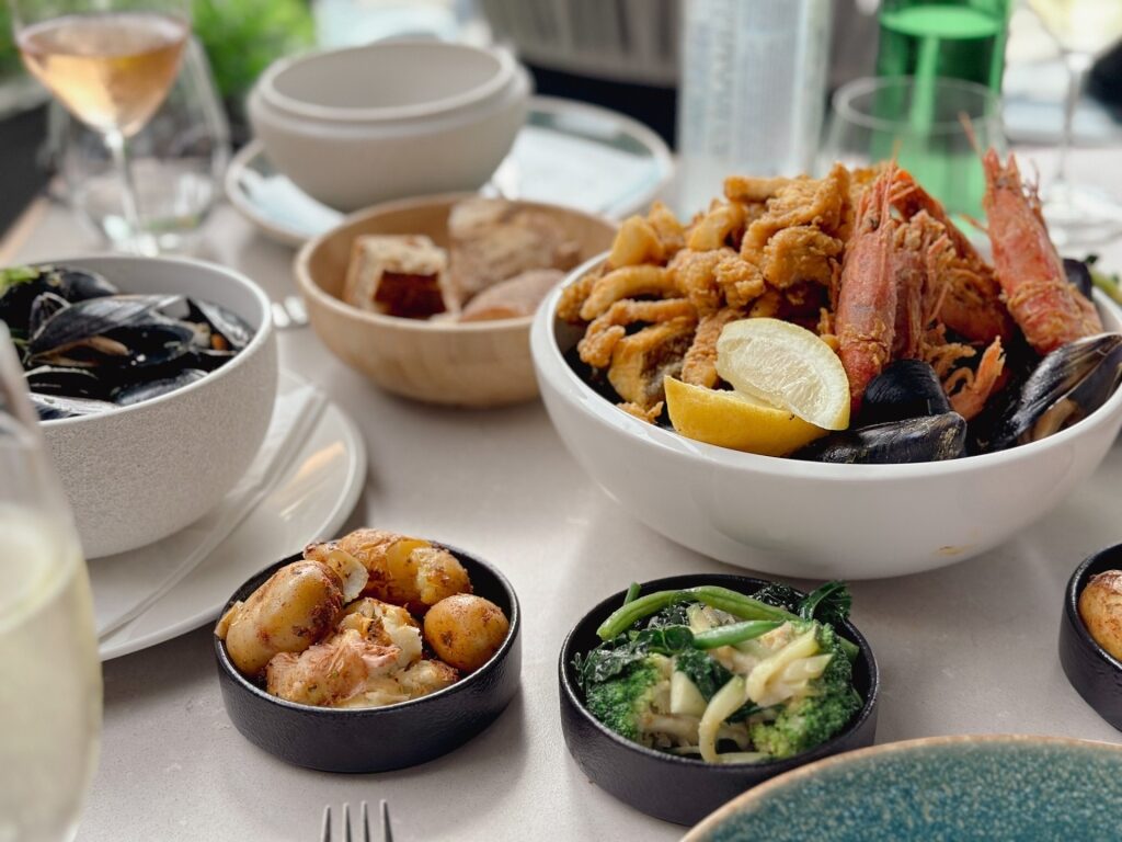 Maltese restaurant meal featuring side dishes and seafood