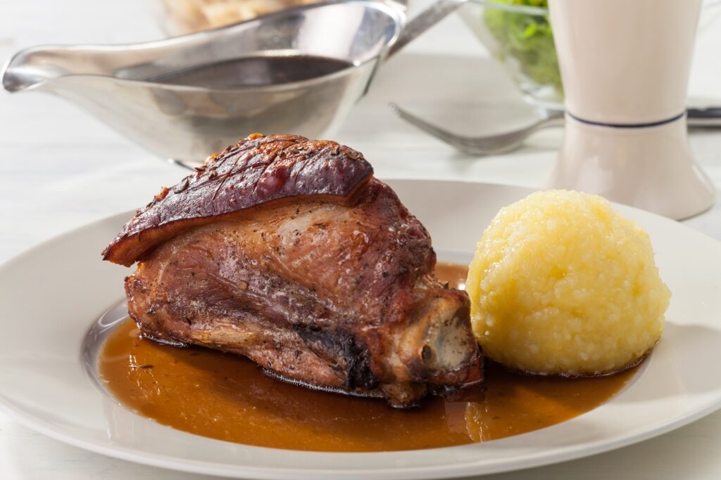 Plate of Schäufele served with dumpling and gravy in Germany