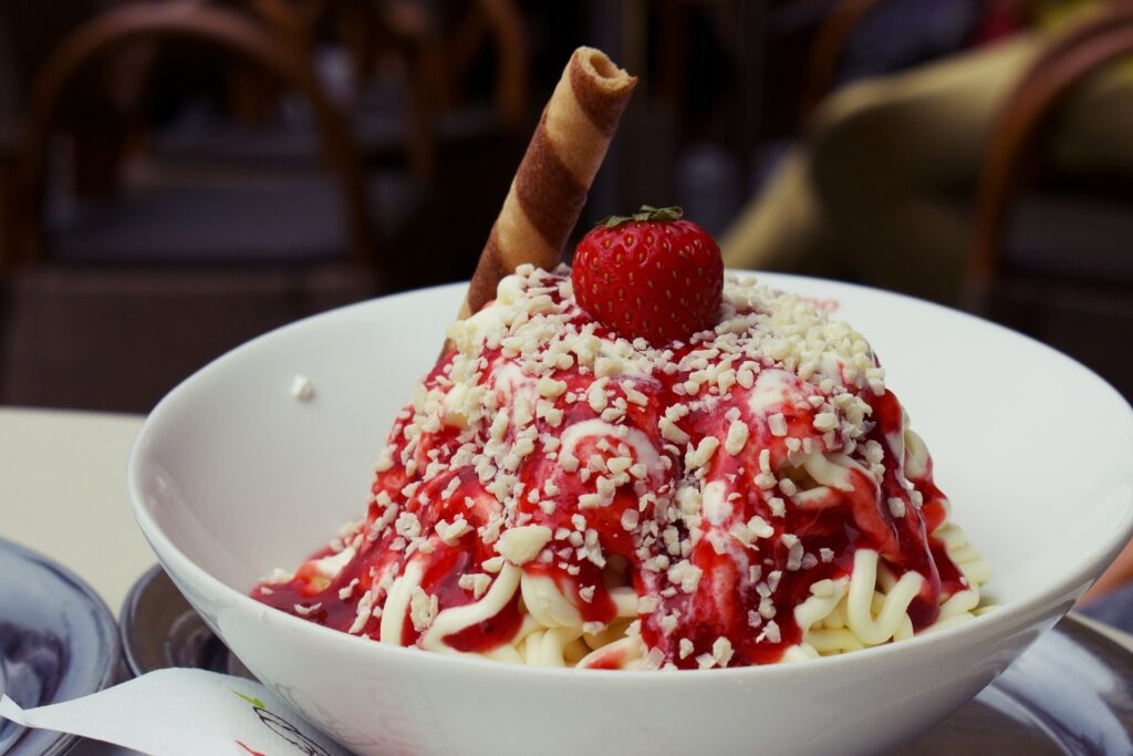 German Spaghettieis dessert served with strawberry and crunchy wafer stick on top