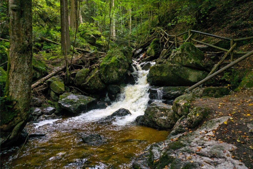 Rushing water flowing through the mossy rocks of Ysperklamm Gorge
