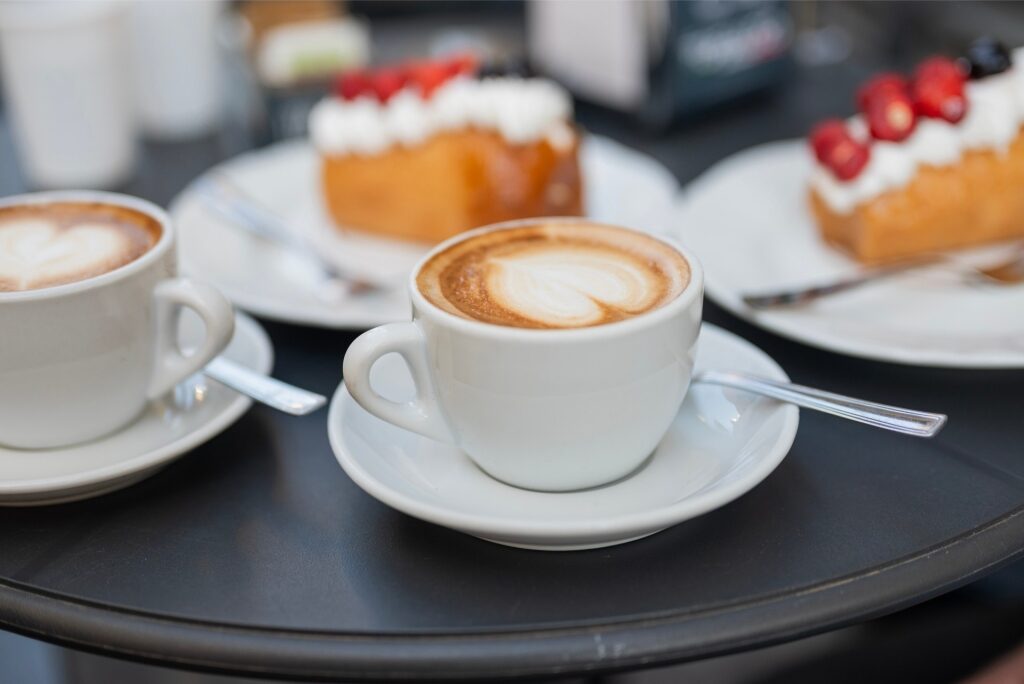 Cappuccino coffee served with sweet rum baba pastries in a Naples restaurant