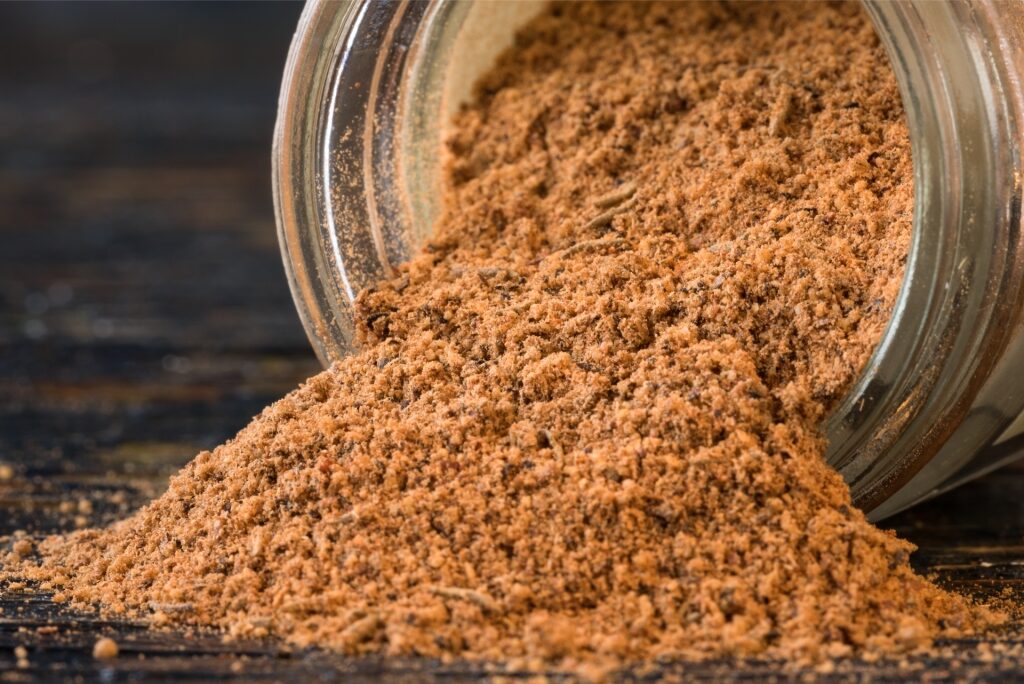 Close-up of jerk seasoning spilled from a glass spice jar