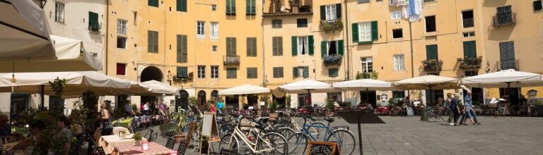 Historic square Piazza dell'Anfiteatro featuring colorful cafés and al fresco tables