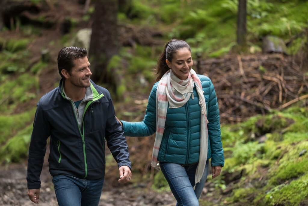 Couple hiking along scenic forest trails on Mt. Fløyen, Norway