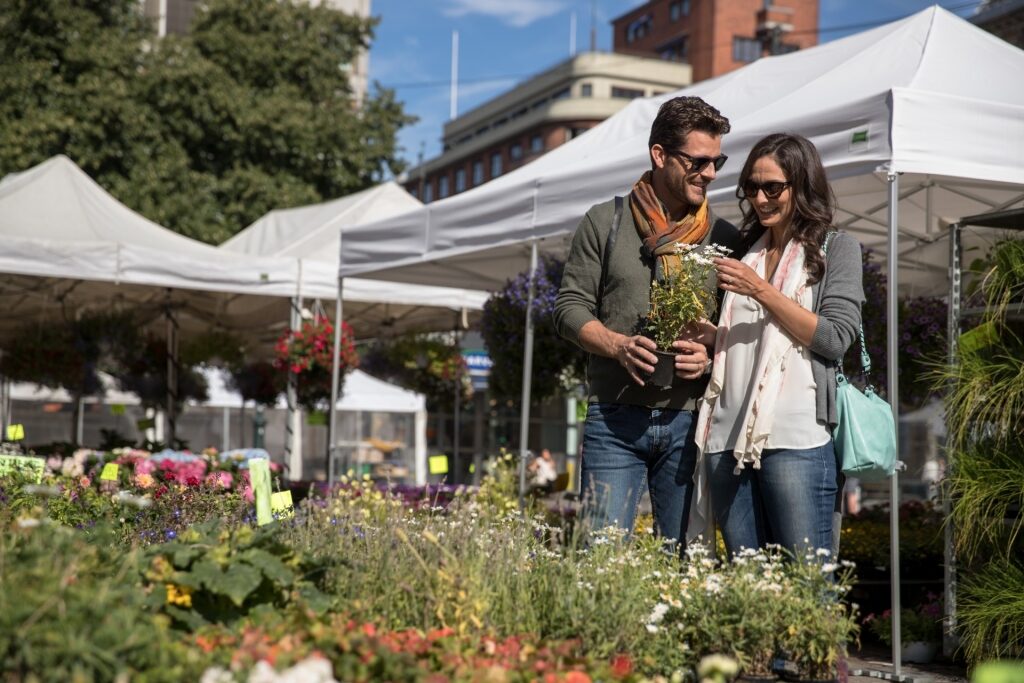 Couple browsing fresh blooms at an outdoor market in Oslo