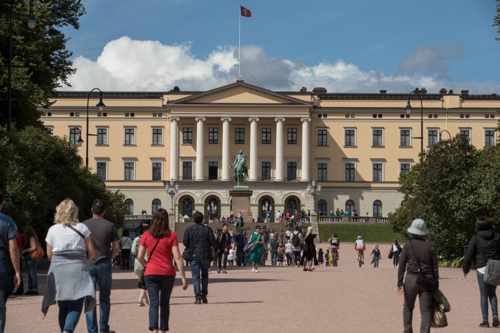 Exterior view of the Royal Palace in Oslo with tourists walking in front