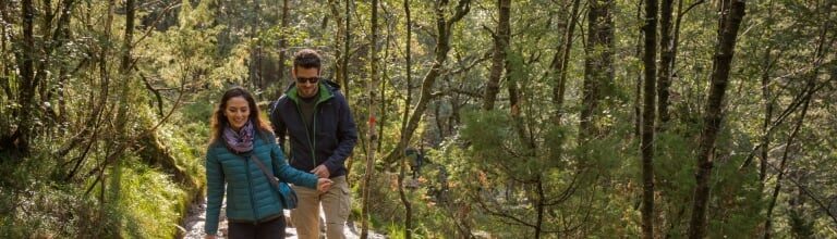 Couple trekking along a rocky trail leading toward Pulpit Rock in Norway