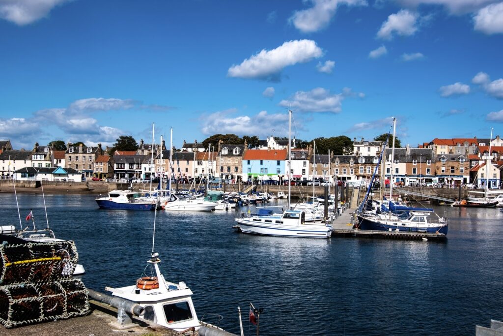 View of Anstruther harbor in Scotland with boats docked along the quay