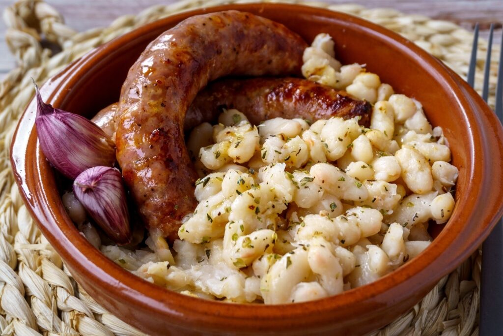 Traditional Catalan botifarra sausage served with white beans on a plate