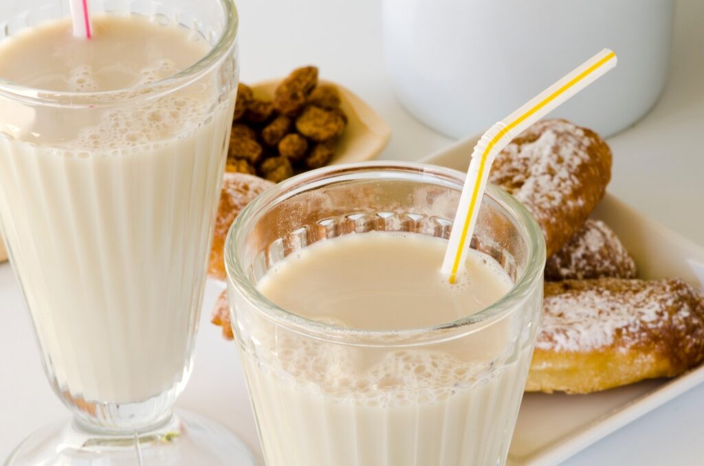 Valencian horchata drink in a clear glass garnished with straw