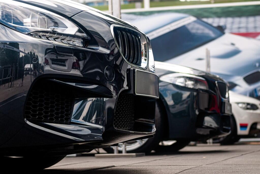 Front bumper view of multiple cars lined up in a parking area