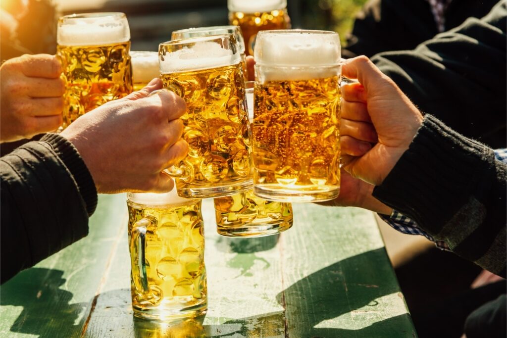 Traditional beer toast with mugs full of golden beer