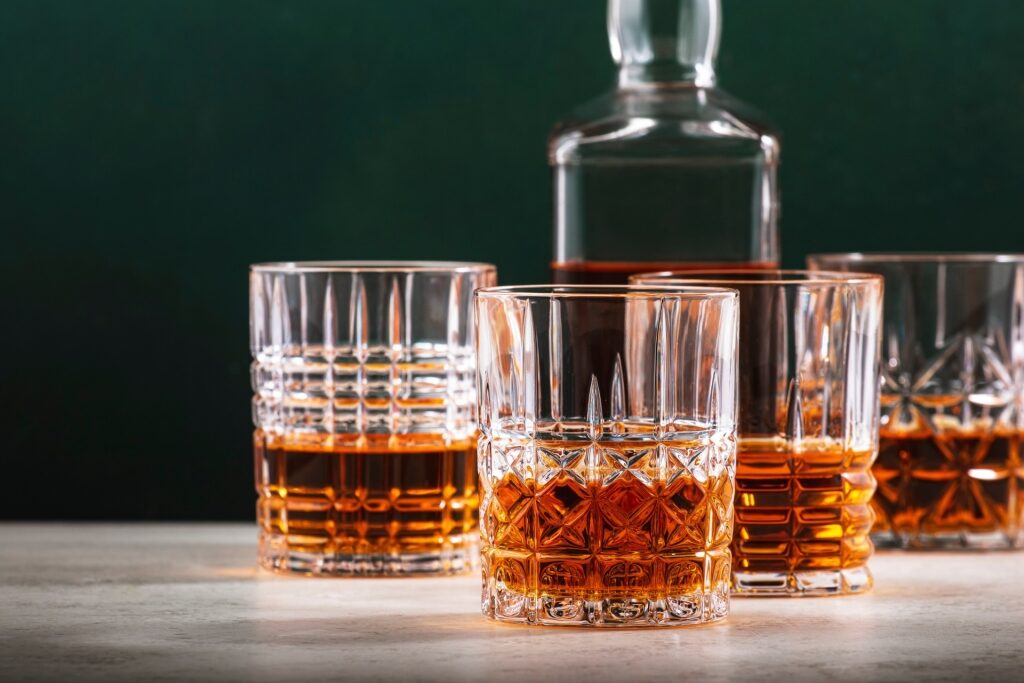 Rich amber Irish whiskey in glasses with its bottle