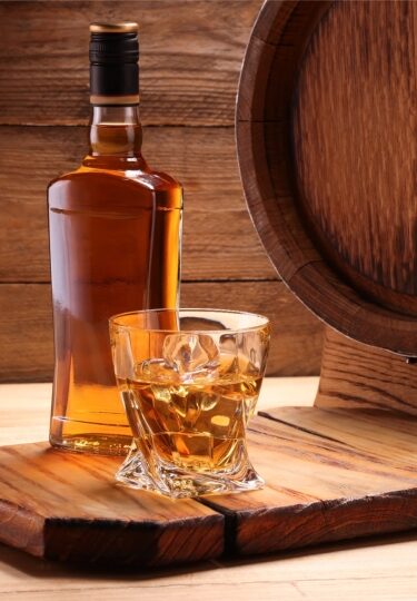 Rich amber Irish whiskey in a glass alongside its bottle