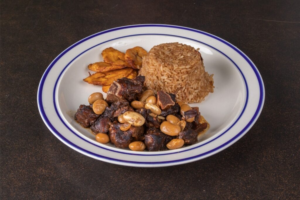 Caribbean-style oxtail stew with rice and peas on a dinner plate