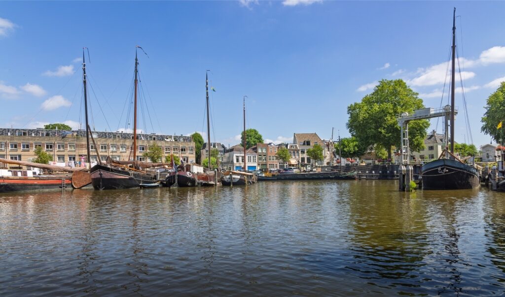 View of traditional vessels moored along a peaceful canal in Gouda
