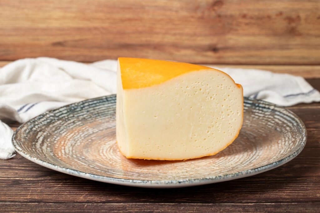 Slice of Gouda cheese with its smooth texture