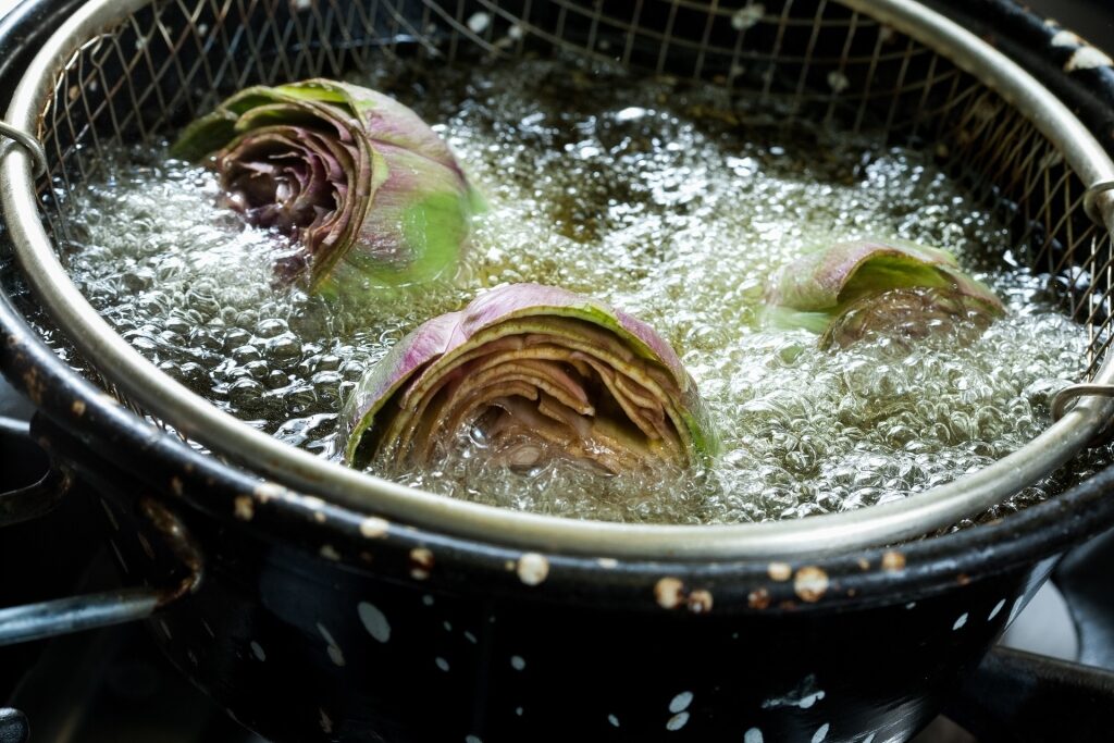 Artichokes frying in a pan