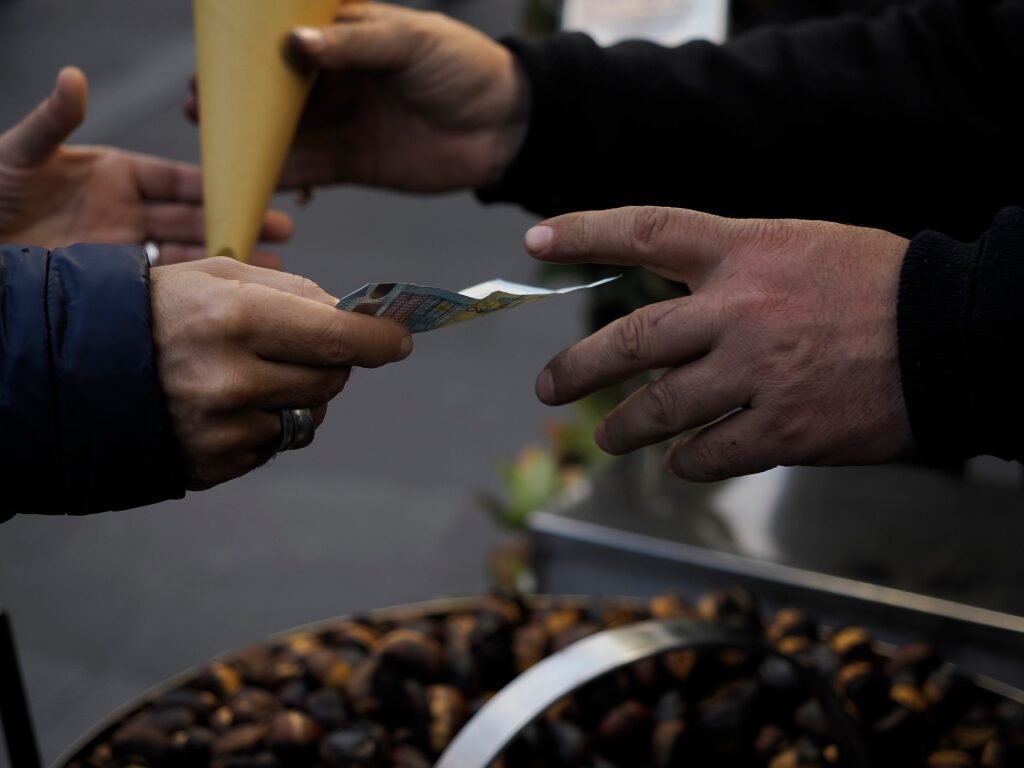 Customer handing cash for street food in a Roman market
